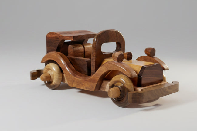 Wooden toy car on a white surface with a blurred background